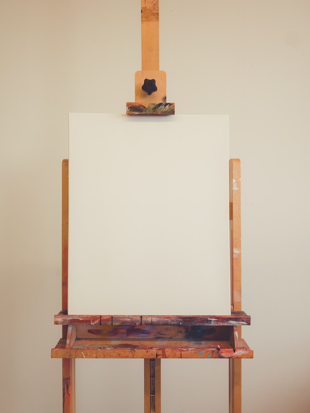 image featuring a close up of a blank canvas positioned on a easel blog post is about how to make a vision board