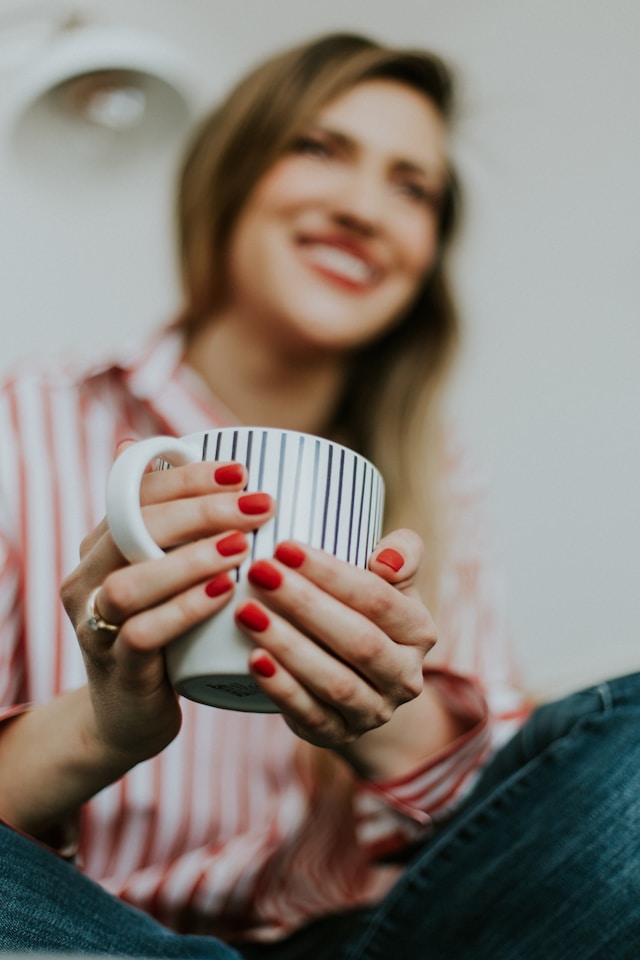 image showing a woman with blonde hair holding a coffee mug the blog post is about checklist morning routine