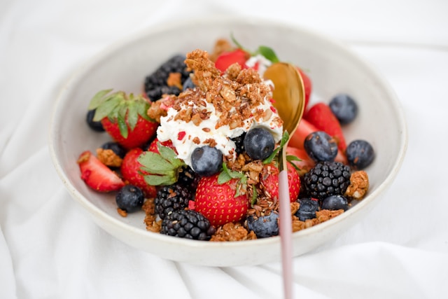 image shows a healthy breakfast bowl with fresh berries, nuts and granola blog post is about creating a mindful morning routine