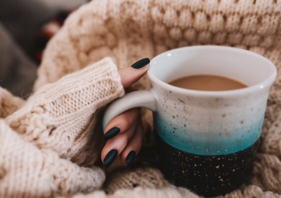 girl wearing knitted jumper sitting on the couch close up on coffee mug develop a morning routine