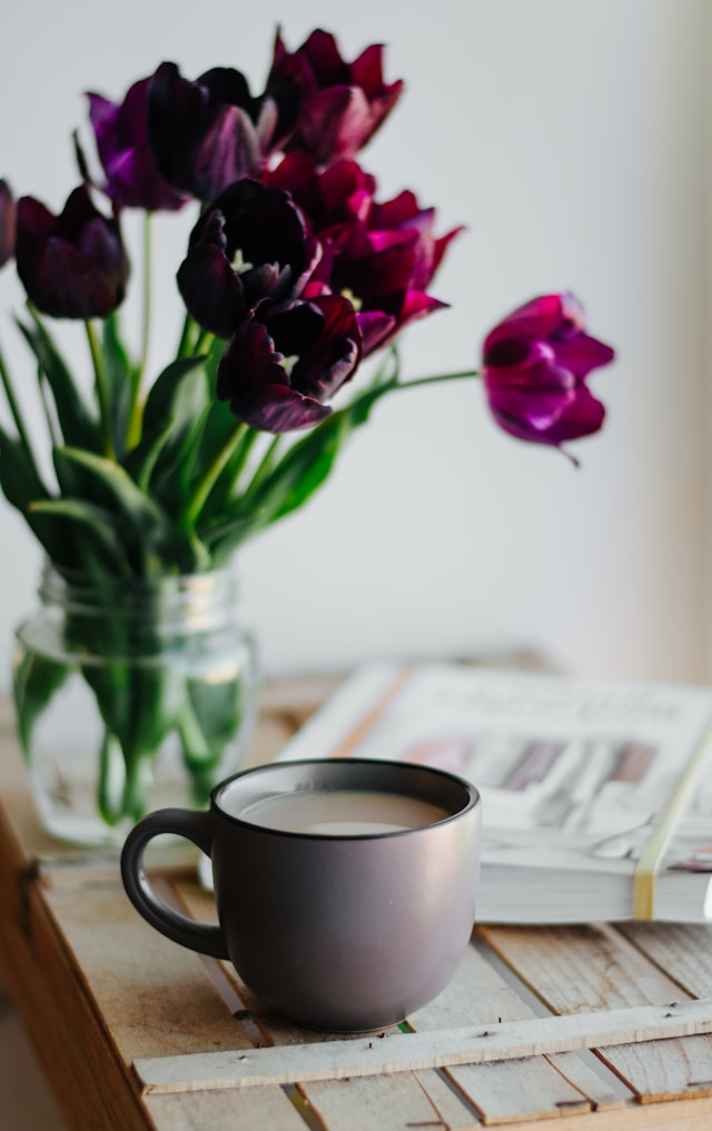 the picture shows purple tulips and a cup of coffee standing on a table and the blog post is about the ultimate morning routine checklist for adults