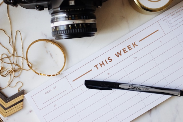 the picture shows a close up of a weekly planner placed on a table and the blog post is about sunday routine ideas to help boost your productivity