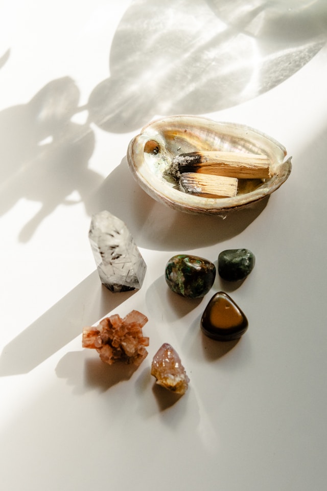 the picture shows crystals and palo santo sticks and the blog post is about yoga room design ideas and meditation room essentials