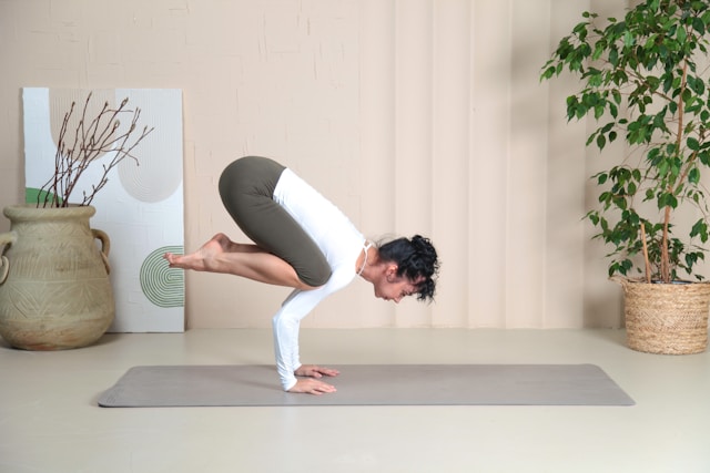 the picture shows a woman doing yoga at home and the blog post is about yoga room design ideas