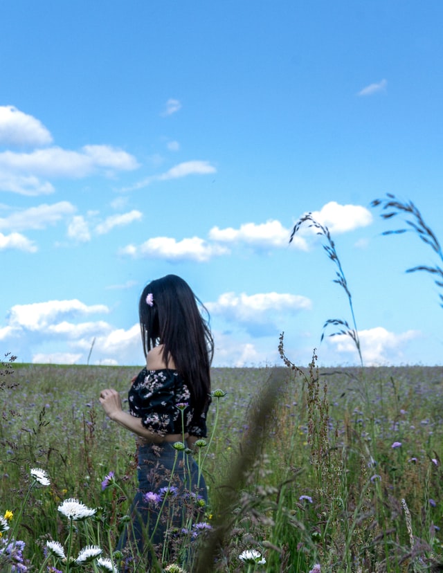 girl with dark hair walking in meadow 5 ways to practise gratitude daily