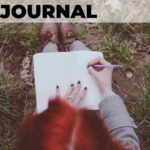 red haired woman sitting on grass outside in nature writing in gratitude journal how to start a gratitude journal