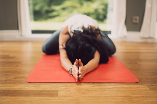 woman on yoga mat 5 best yoga props for your home yoga practice