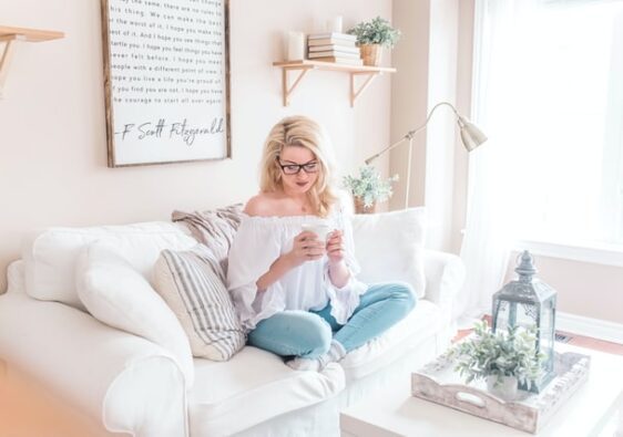 blonde woman sitting on couch how to declutter your life