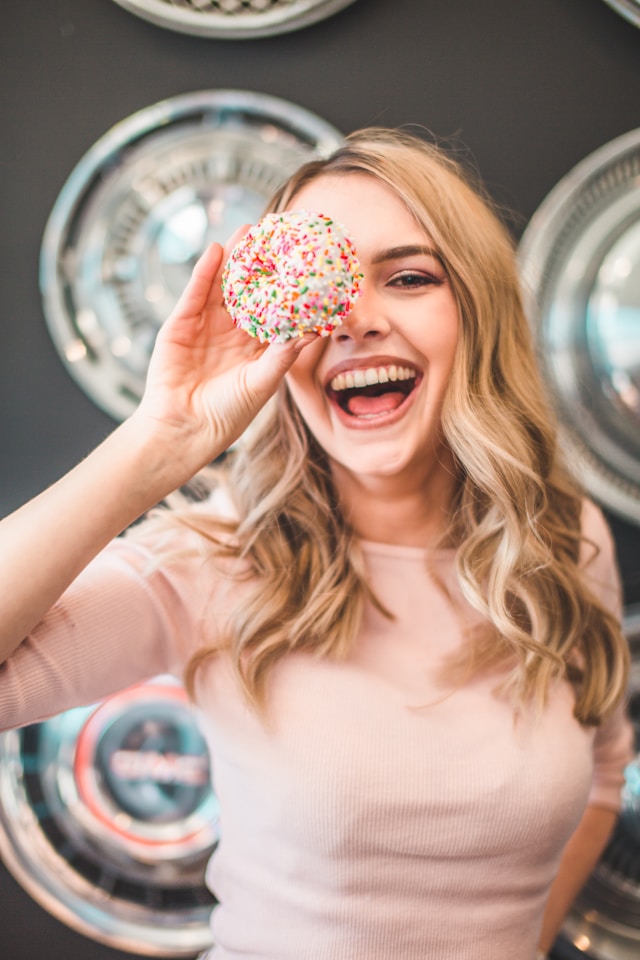 image showing blonde young woman smiling holding a round ball sweet in front of her face blog post is about the importance of core values in life