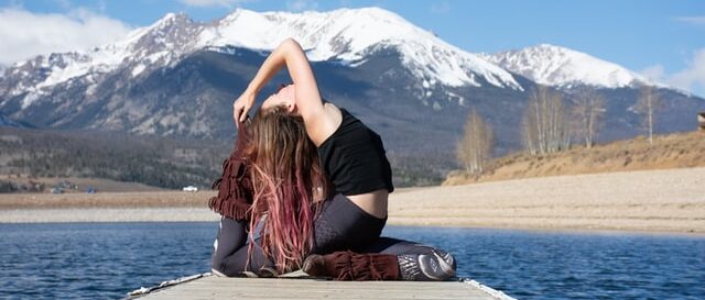 girl doing mermaid yoga pose on pier in front of mountains 11 reasons why you should start yoga