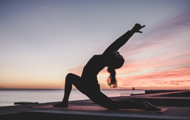 woman doing yoga in evening light at waterside 11 reasons to start yoga