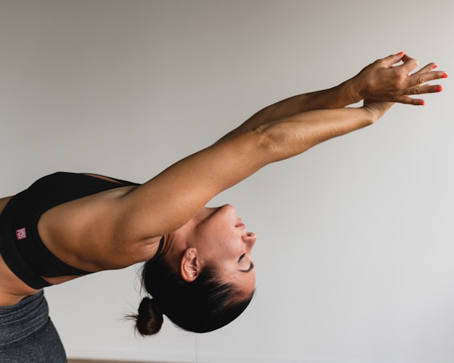 image showing a close up of a woman's upper body ding a deep backbend blog post is about 20 benefits of yoga