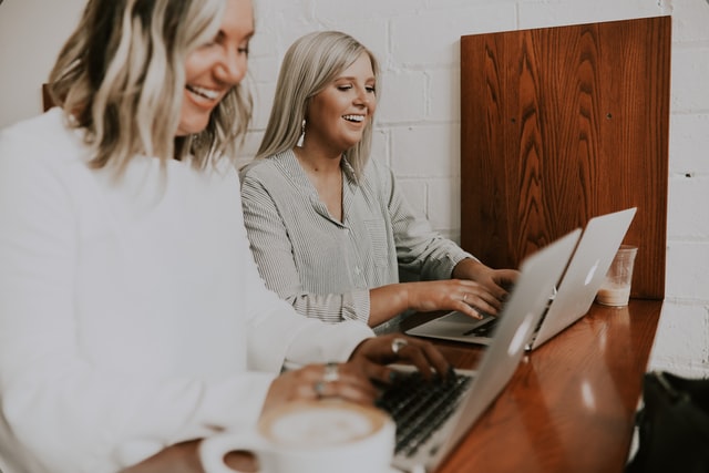 two blonde women helping each other at work how to practice self-care at work