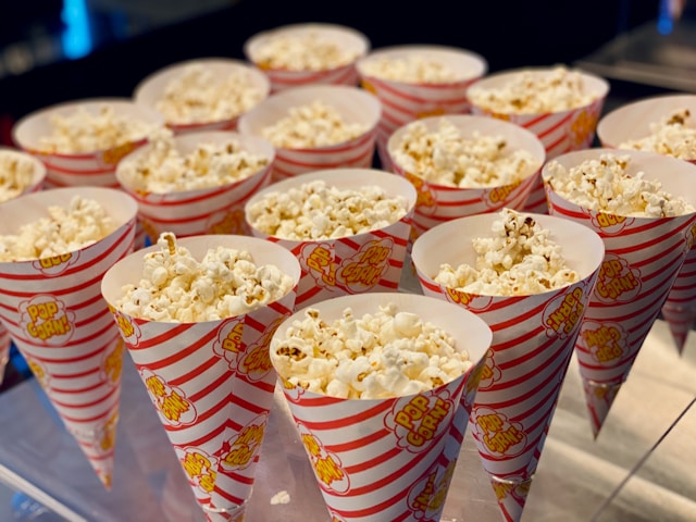 the picture shows popcorn bags filled with popcorn and the blog post is about summer self-care ideas and this one is about an outdoor cinema experience