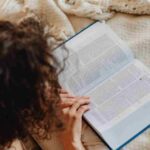 Pinterest pin image showing woman reading book on bed evening routine checklist
