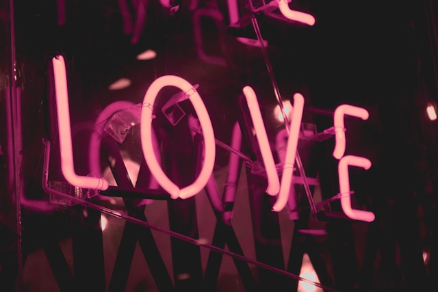 image showing close up of LOVE written as word in neon pink colours and black background blog post is about crafting an evening routine