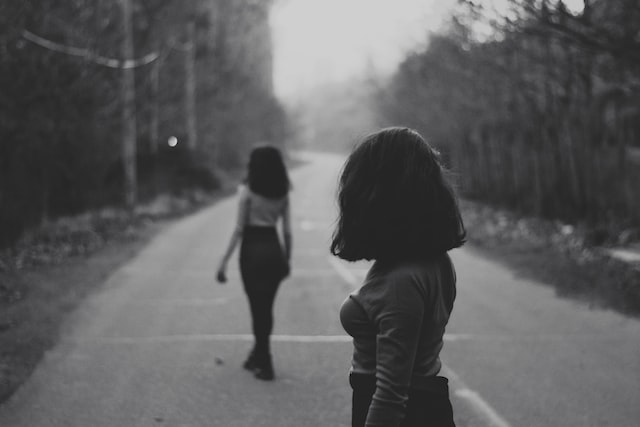black and white image of two women walking away from each other after conflict how to do shadow work