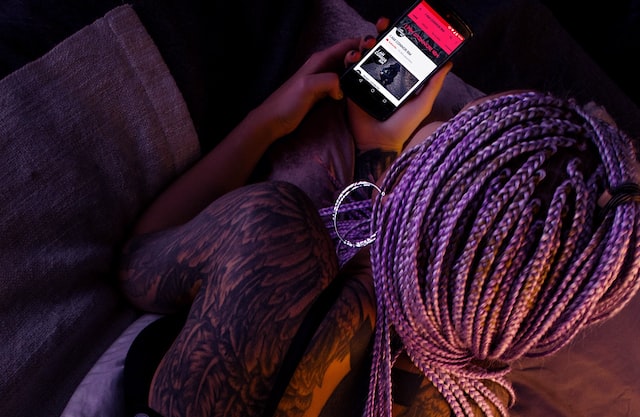 woman with purple hair holding mobile phone relax before bed switch off your mobile phone