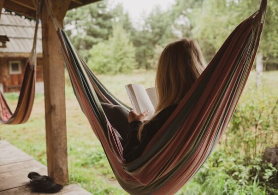 woman in hammock reading a book outside on veranda 11 easy ways to relax when stressed