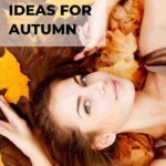 woman looking into camera lying on bed of autumn leaves close up of her head blog post is about autumn self care ideas