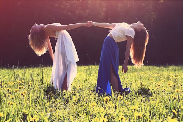 two women in summer meadow dancing in sunshine toxic habits to quit don't be with people who do not appreciate you