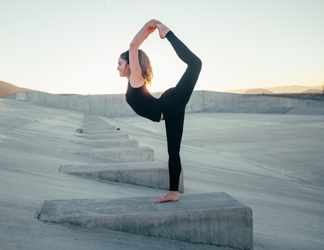 image showing a woman doing dancers pose in yoga blog post is about how yoga helps to boost the immune system