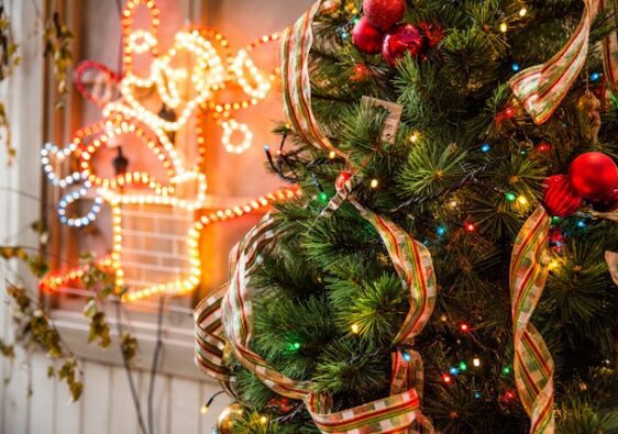 image shows a close up of a Christmas tree with beautiful Christmas lights next to it and gives a very festive feeling the blog post is about navigating the festive season and self-care at Christmas tips