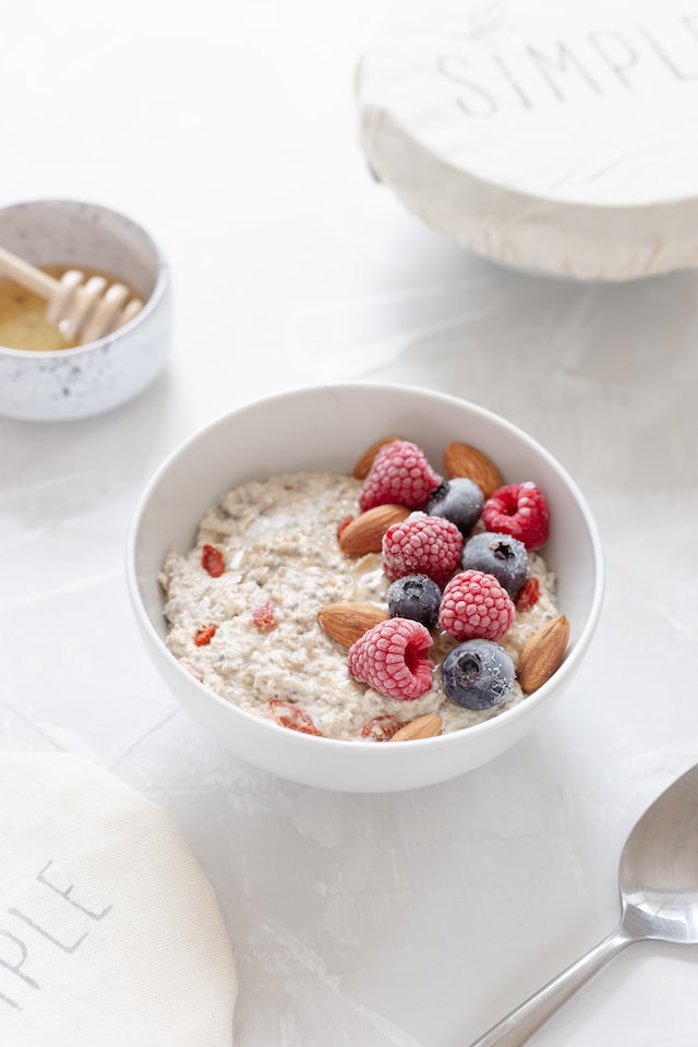 bowl of oatmeal topped with berries and almonds post yoga snacks