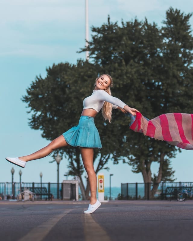 the picture shows a woman confidently walking on a street, the woman is happy and smiling and enjoying life the blog post is about 33 ways to pamper yourself
