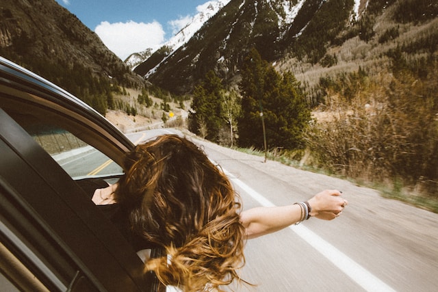 image showing woman leaning out of car window enjoying a moment of freedom 7 ways to overcome procrastination
