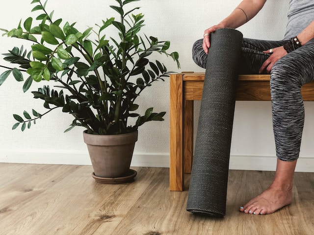 picture showing close up of yoga mat you can also see part of a woman waiting for yoga class to start first yoga class what to bring
