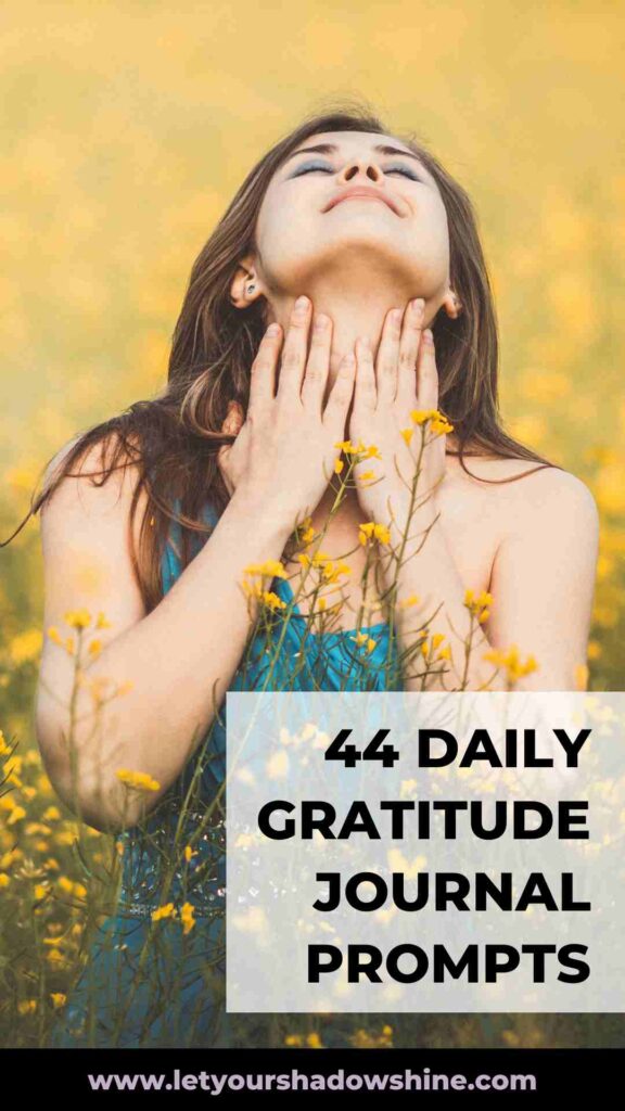 woman with long brown hair standing in field wearing a green dress enjoying a moment of deep gratitude daily gratitude journal prompts