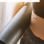 Pinterest pin image showing close up of a woman wearing a black yoga outfit and carrying a black yoga mat blog post is about the best black yoga pants from Amazon