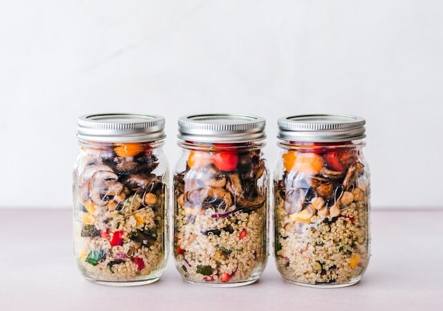 image showing three glass jars with healthy meal prep salads blog post is about meal prep for busy professionals