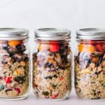 image showing three glass jars with healthy meal prep salads blog post is about meal prep for busy professionals