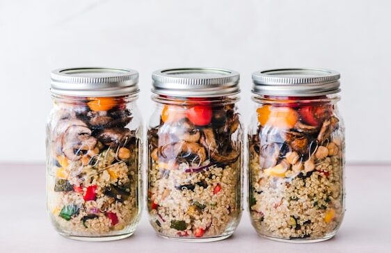 image showing three glass jars with healthy meal prep salads blog post is about meal prep for busy professionals