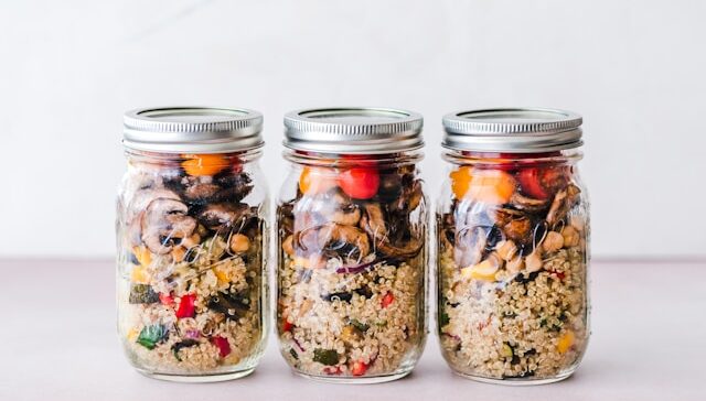 image showing three glass jars with healthy meal prep salads blog post is about meal prep for busy professionals