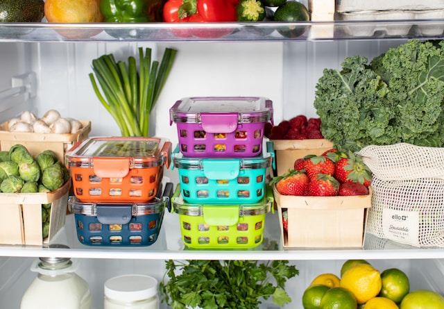 image shows a close up of the inside of a fridge with lots of food containers and fresh vegetables inside blog post is about meal prep for busy professionals