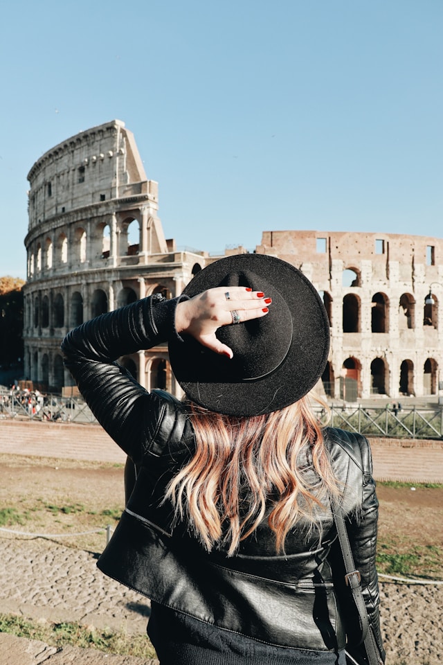 image shows a woman from the back standing in front of the Colosseum in Rome blog post is about how solo travel changes you