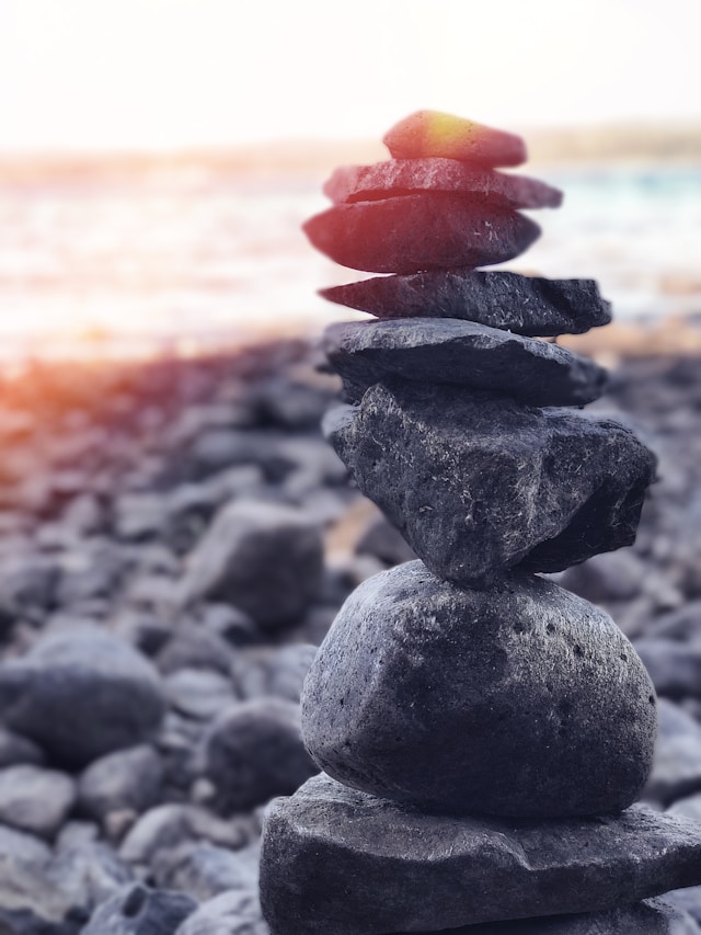 the image shows stones placed on top of each other representing balance and the blog post is about mindfulness and grounding techniques