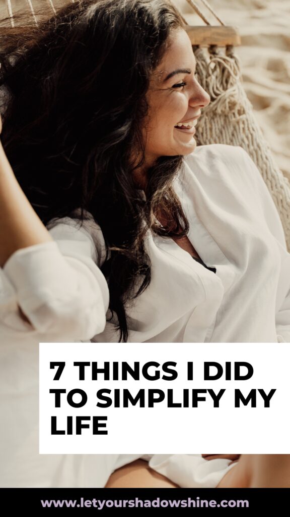 Pinterest pin shows a woman sitting in a comfortable arm chair smiling and feeling content the blog post is about powerful tips to simplify life